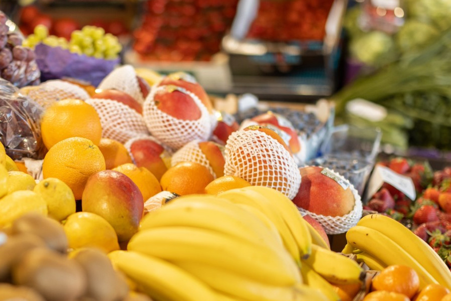 Frische Obsttheke mit Bananen, Orangen, Mangos und anderem bunten Obst.